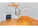 Comfortable living room boasting hardwood floors, a cozy fireplace, and a staircase leading upstairs at 6128 Warrior Ave, Fort Mill, SC 29707