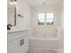 Bright bathroom featuring a window, white cabinets, modern fixtures, and a soaking tub at 7006 Lone Eagle Dr # 18, Monroe, NC 28110