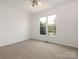 Cozy bedroom with neutral carpet, ceiling fan, and a large window offering natural light at 7006 Lone Eagle Dr # 18, Monroe, NC 28110