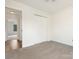 Bedroom featuring neutral carpet and a glimpse into a hallway with wood flooring at 7006 Lone Eagle Dr # 18, Monroe, NC 28110