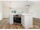 Open kitchen features an oven with custom hood, white cabinets, and hardwood flooring at 7006 Lone Eagle Dr # 18, Monroe, NC 28110