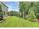 Expansive backyard with green grass, mature trees and a stone patio at 7011 Hyde Park Dr, Indian Trail, NC 28079