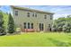 Green backyard with brick patio, lawn, mature trees offer serene outdoor space at 7011 Hyde Park Dr, Indian Trail, NC 28079
