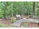 Cozy backyard setting with a gravel area, fire pit, mature trees, and a hammock for relaxation at 7011 Hyde Park Dr, Indian Trail, NC 28079