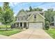 Charming two-story home featuring a manicured lawn, a two-car garage, and classic architectural details at 7011 Hyde Park Dr, Indian Trail, NC 28079