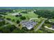 Aerial view of a well-maintained golf course with a clubhouse, parking lot, pond, and driving range at 7011 Hyde Park Dr, Indian Trail, NC 28079