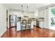 Open-concept kitchen boasts stainless steel appliances, an island with seating, and hardwood flooring at 7011 Hyde Park Dr, Indian Trail, NC 28079