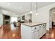 Open floor plan featuring a kitchen island with granite countertop, pendant lighting and views of the stone fireplace at 7011 Hyde Park Dr, Indian Trail, NC 28079