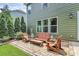 Inviting brick patio with wooden furniture and lush landscaping offers a perfect outdoor living space at 7011 Hyde Park Dr, Indian Trail, NC 28079