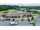 An aerial view of a strip mall with various retail businesses, green landscaping, and easy parking at 7011 Hyde Park Dr, Indian Trail, NC 28079