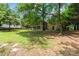 Expansive backyard with mature trees, offering a private and serene outdoor space at 8007 Caldwell Rd, Harrisburg, NC 28075