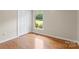 Bedroom with hardwood floors and a double-door closet and a window view at 8007 Caldwell Rd, Harrisburg, NC 28075