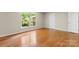 Bright bedroom features hardwood floors and a large window overlooking a tree-filled yard at 8007 Caldwell Rd, Harrisburg, NC 28075