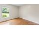 Cozy bedroom with hardwood floors, base trim and a window overlooking the lawn at 8007 Caldwell Rd, Harrisburg, NC 28075