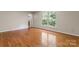 This bedroom has hardwood floors, a double window, and an ensuite bathroom at 8007 Caldwell Rd, Harrisburg, NC 28075