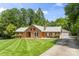 Charming one-story brick home features a well-manicured lawn and an inviting entrance with mature trees surrounding the property at 8007 Caldwell Rd, Harrisburg, NC 28075