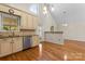 A kitchen with wooden floors, cream colored cabinets, stainless steel appliances, and granite countertops at 8007 Caldwell Rd, Harrisburg, NC 28075