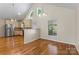 The kitchen has stainless steel appliances, cream colored cabinets, wood floors and large windows at 8007 Caldwell Rd, Harrisburg, NC 28075