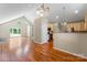The large living room features wood floors and tall ceilings with an open view to the kitchen at 8007 Caldwell Rd, Harrisburg, NC 28075