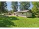 Well-maintained backyard featuring a lush green lawn and a charming white brick home at 848 Ike Lynch Rd, Dallas, NC 28034