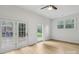 Well-lit bedroom with hardwood floors, ceiling fan, and natural light from multiple windows and doors at 848 Ike Lynch Rd, Dallas, NC 28034