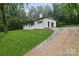 Well-maintained white home features a long driveway and lush greenery at 848 Ike Lynch Rd, Dallas, NC 28034