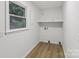 A bright laundry room with a window, a shelf, and hardwood floors at 848 Ike Lynch Rd, Dallas, NC 28034