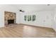 A large, bright living room boasts a brick fireplace, new floors, multiple windows and a ceiling fan at 848 Ike Lynch Rd, Dallas, NC 28034