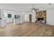 Open-concept space with brick fireplace, new floors, and adjoined to the modernized kitchen at 848 Ike Lynch Rd, Dallas, NC 28034