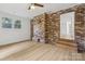 Cozy living room featuring a brick accent wall, hardwood floors, and lots of natural light at 848 Ike Lynch Rd, Dallas, NC 28034