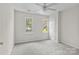 Bright bedroom features two windows, neutral carpeting, and a ceiling fan with lighting at 9904 Brigstock Ct, Charlotte, NC 28269