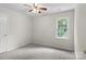 Simple bedroom featuring carpeted floors, a ceiling fan, and a window that fills the room with natural light at 9904 Brigstock Ct, Charlotte, NC 28269