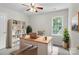 Bright home office featuring built-in shelving, a wooden desk, and natural light from the window at 9904 Brigstock Ct, Charlotte, NC 28269