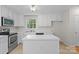 Clean kitchen featuring white cabinets, an island, stainless steel appliances and a window at 9904 Brigstock Ct, Charlotte, NC 28269