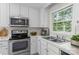 Modern kitchen with white cabinets, stainless steel appliances, and ample counter space at 9904 Brigstock Ct, Charlotte, NC 28269