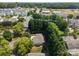 An aerial view shows a home surrounded by lush trees and greenery in a quiet, suburban neighborhood at 110 Whitehall Dr, Mooresville, NC 28117