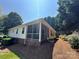 View of rear elevation with a screened-in porch and a well-maintained yard at 110 Whitehall Dr, Mooresville, NC 28117
