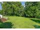Wide backyard featuring large, grassy area and a white railing on deck steps at 1107 Fairfield Dr, Gastonia, NC 28054