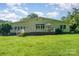 Lush backyard featuring expansive grassy area, shade trees, and a deck at 1107 Fairfield Dr, Gastonia, NC 28054