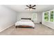 Relaxing bedroom with a ceiling fan, large windows, and neutral carpeting at 1107 Fairfield Dr, Gastonia, NC 28054