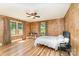 Bedroom with paneled walls, hardwood floors, bright windows, and ceiling fan at 1107 Fairfield Dr, Gastonia, NC 28054