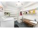 Bright laundry room with washer, dryer, open shelving, and folding table at 1107 Fairfield Dr, Gastonia, NC 28054