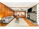 Comfortable living room with a stone fireplace, wood paneling, and ample natural light at 1107 Fairfield Dr, Gastonia, NC 28054