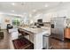Bright modern kitchen featuring white cabinets, stainless appliances, island with breakfast bar overlooking the living room at 1132 Whitby Moore St, Charlotte, NC 28273