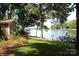 Lakefront backyard with a lush lawn, mature trees and a private dock for enjoying waterfront living at 114 Caraway Ln, Mooresville, NC 28117