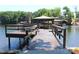 A long wooden dock with a covered boat lift and seating area, showcasing lakefront living at 114 Caraway Ln, Mooresville, NC 28117