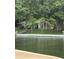 Charming lakeside home with mature trees, grassy lawn, and a covered porch for relaxing outdoors at 114 Caraway Ln, Mooresville, NC 28117