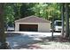 Spacious detached garage with gravel driveway, suitable for multiple vehicles and storage, near lush woods at 114 Caraway Ln, Mooresville, NC 28117