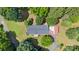 Overhead view of the property highlighting its roof, driveway, and vibrant green yard surrounded by shade trees at 125 Brasington Ln, Mooresville, NC 28115