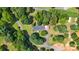 Aerial view of a cozy home nestled among mature trees, featuring a long driveway and well-maintained lawn at 125 Brasington Ln, Mooresville, NC 28115